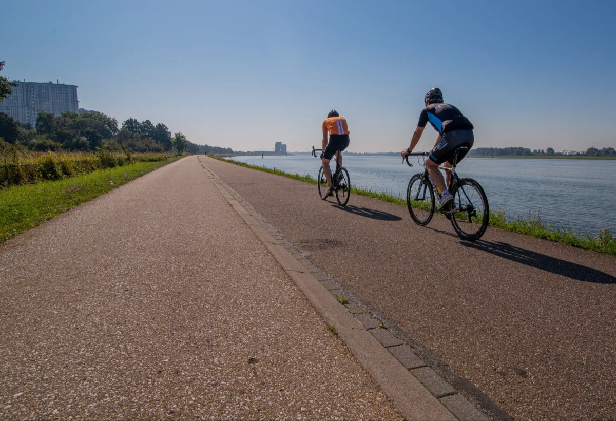 Twee fietsers fietsen langs het water